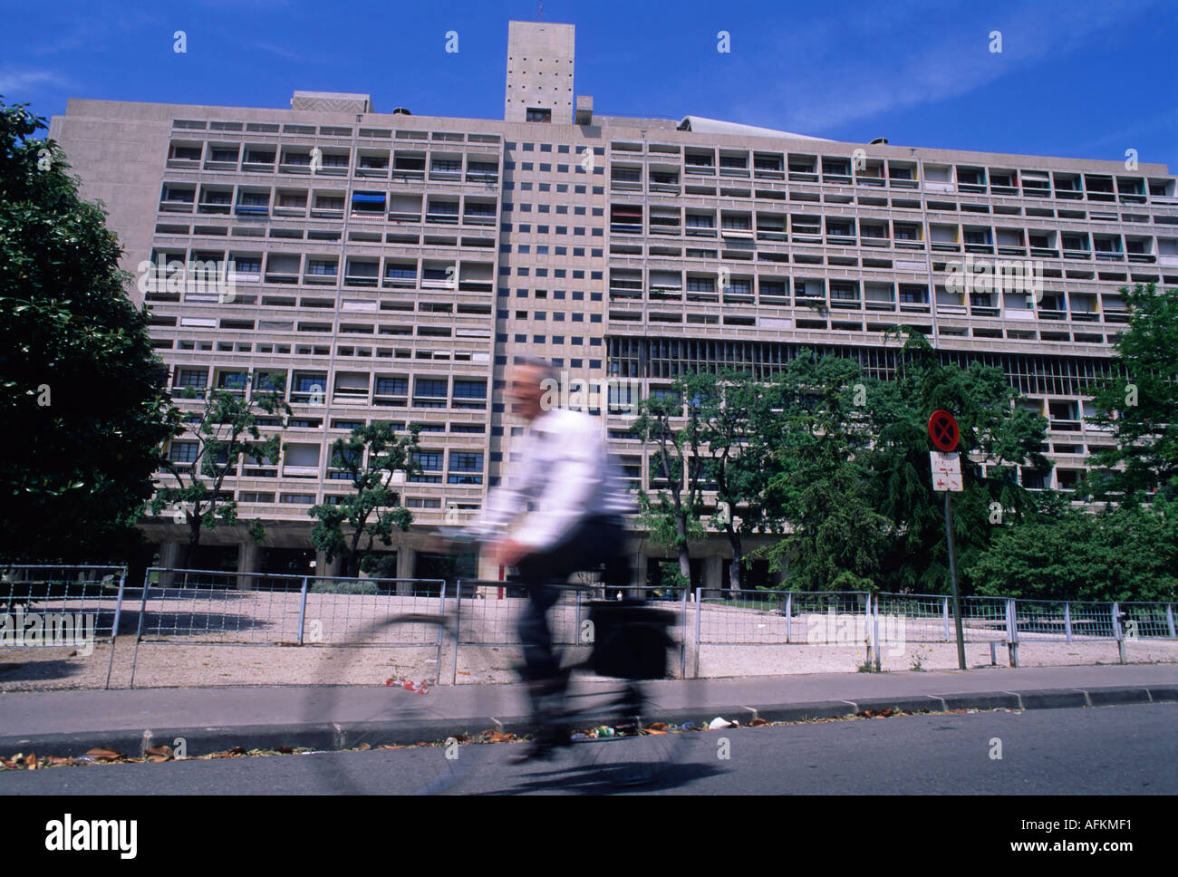 Cyclist passing the Cite Radieuse, a modernist residential housing complex designed by Le Corbusier, in Marseille, France. Stock Photo