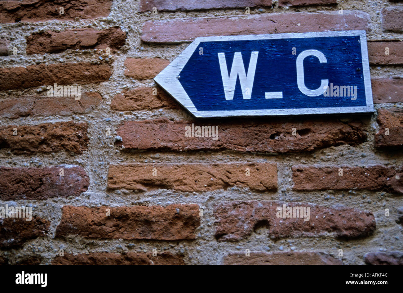 Water closet (toilet) sign on a brick red wall, Albi, France. Stock Photo