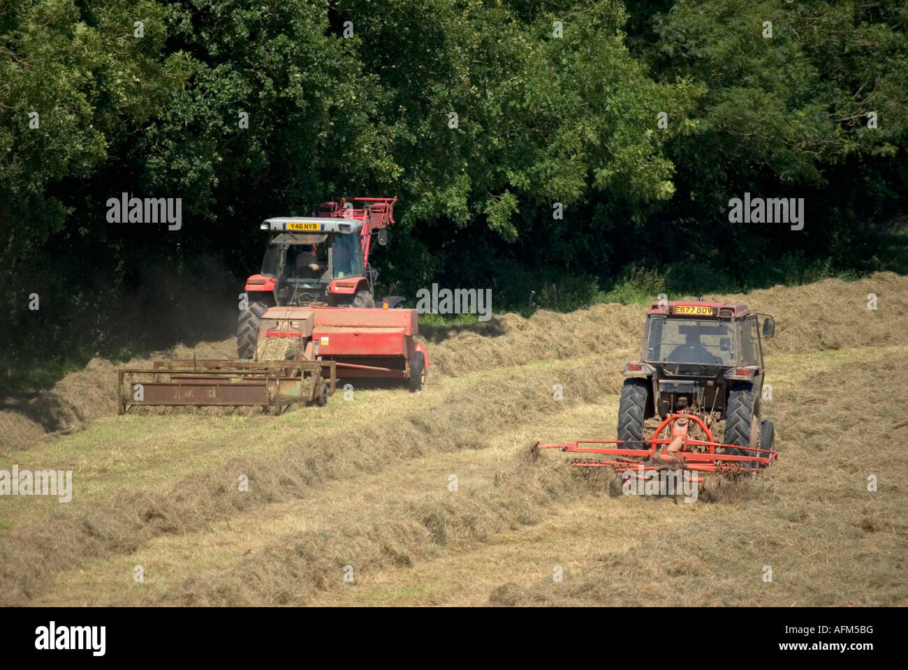 Two tractors baling hay Stock Photo Alamy