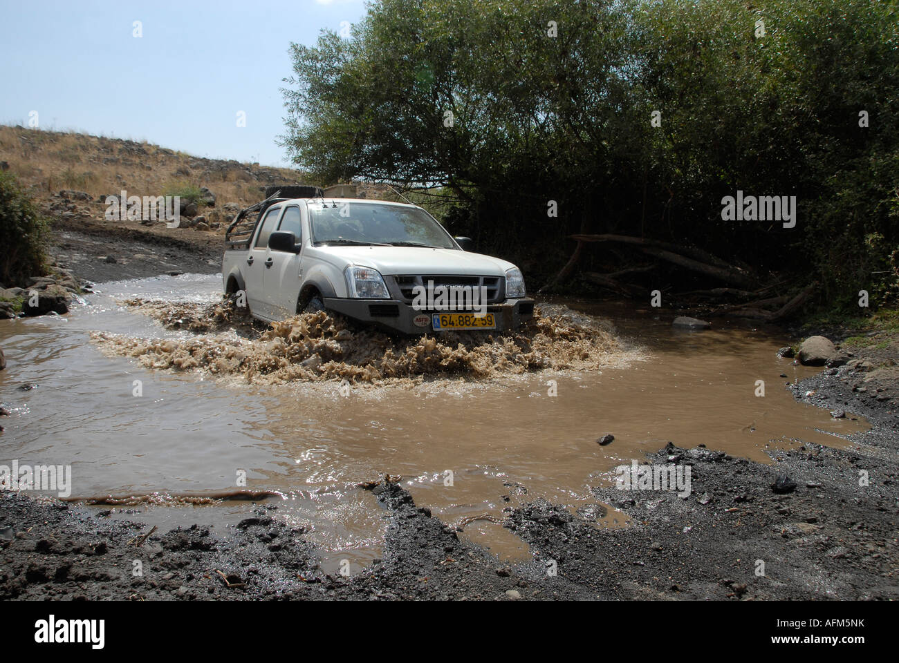 Pickup truck crossing sludge area in the Golan heights. Israel Stock Photo