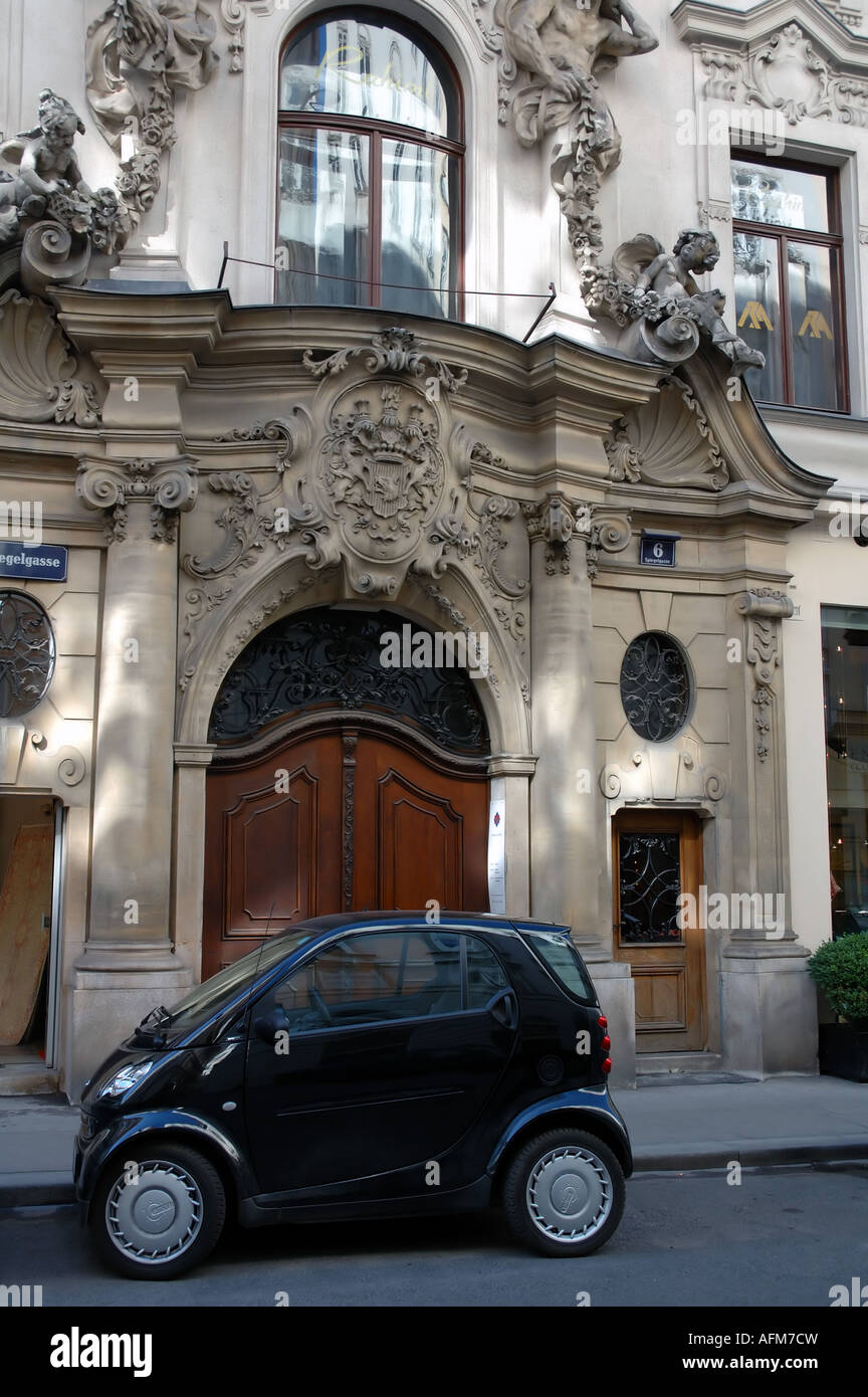 Tiny Smartcar parked outside ornate apartment block entrance First District of Vienna Austria No PR Stock Photo