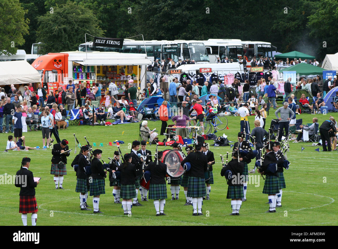 Scottish band in kilts playing bagpipes and drums at highland games
