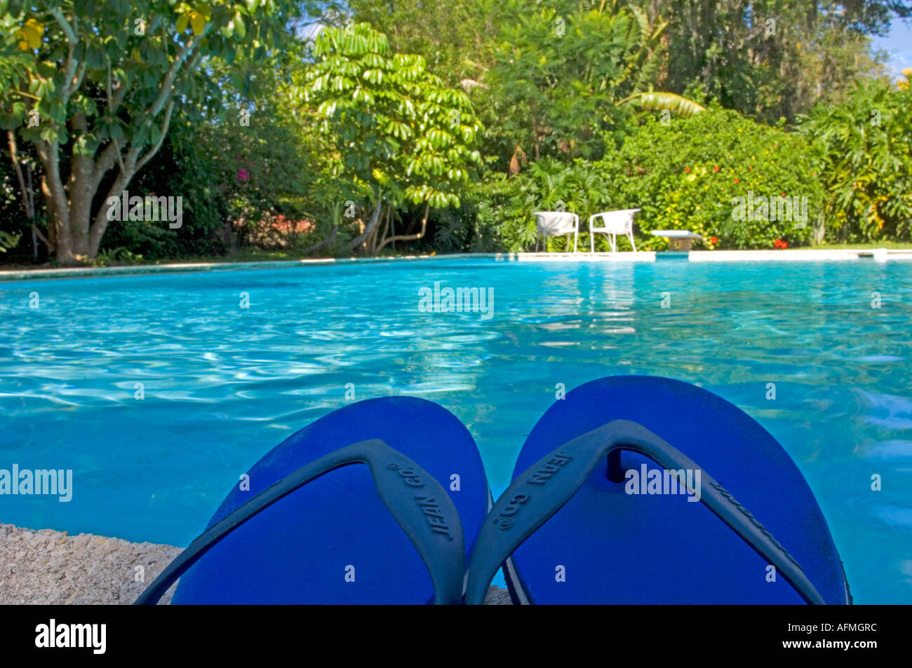sandals lying by tropical pool in resort area Stock Photo