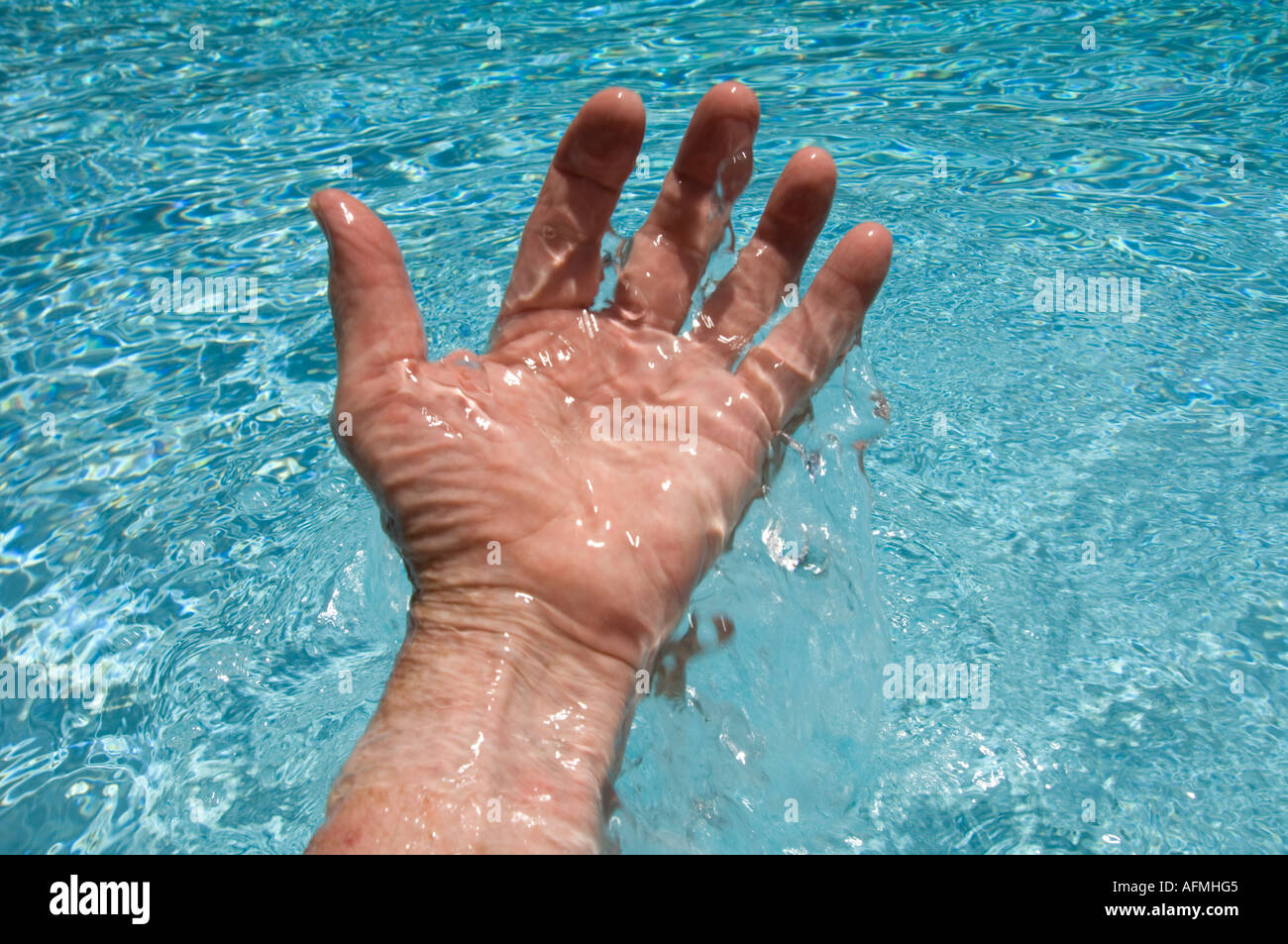 closeup of hand splashing in pool Stock Photo