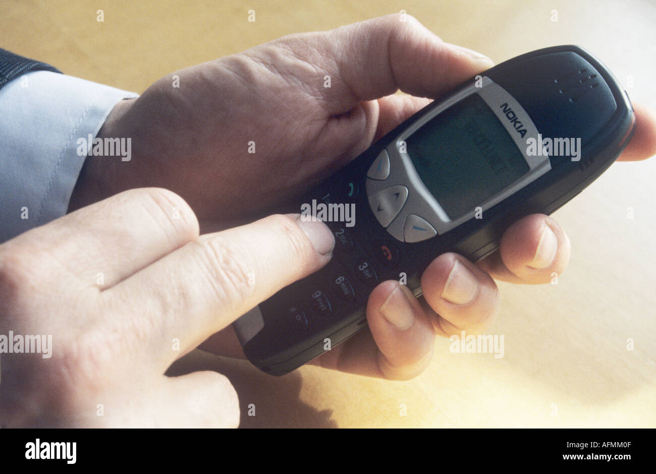 Man dialling a mobile telephone Stock Photo