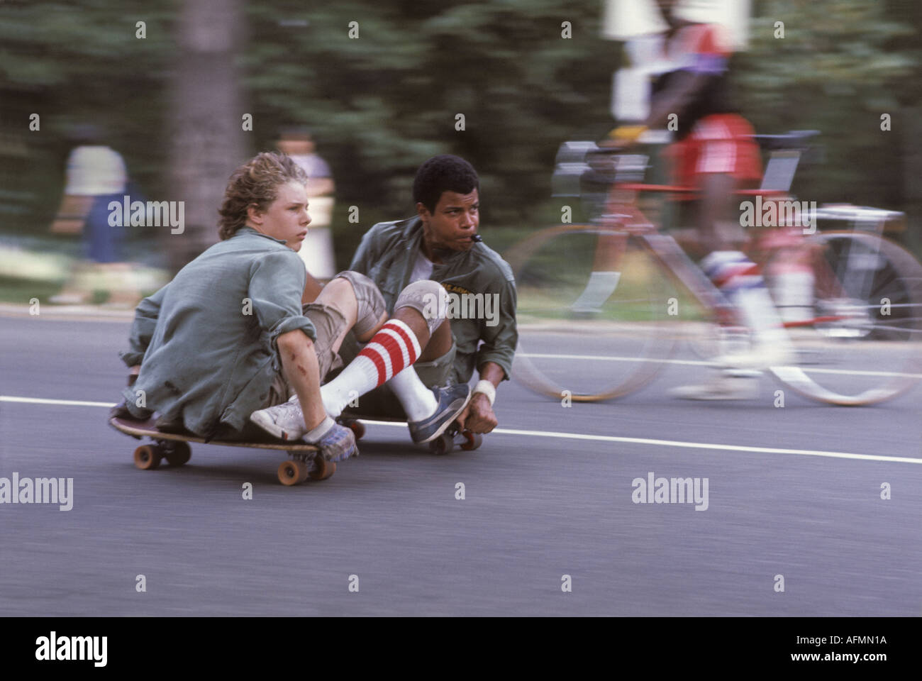 'Two ^teenage boys ^skateboarding, ^linked together, 'Central Park', ^Manhattan, New York' Stock Photo