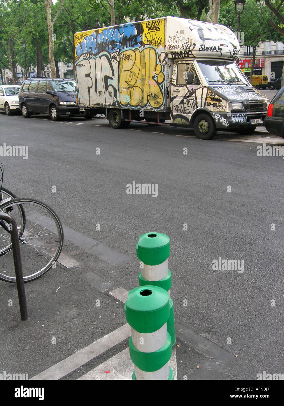 Urban street scene with vandalised graffiti covered minivan parked in Boulevard Voltaire Paris France Stock Photo