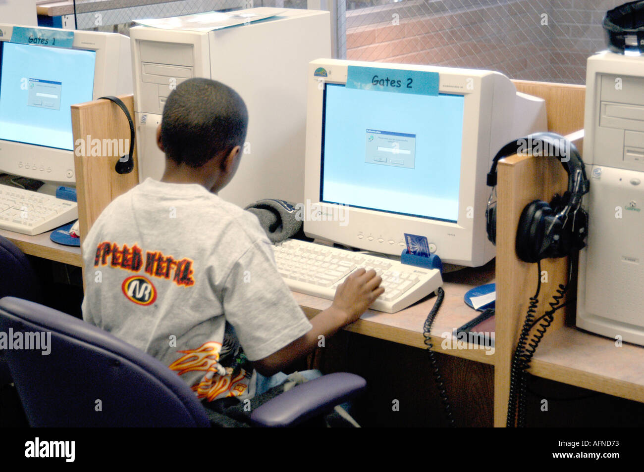 Black boy working at a computer on reading in a public library Stock Photo