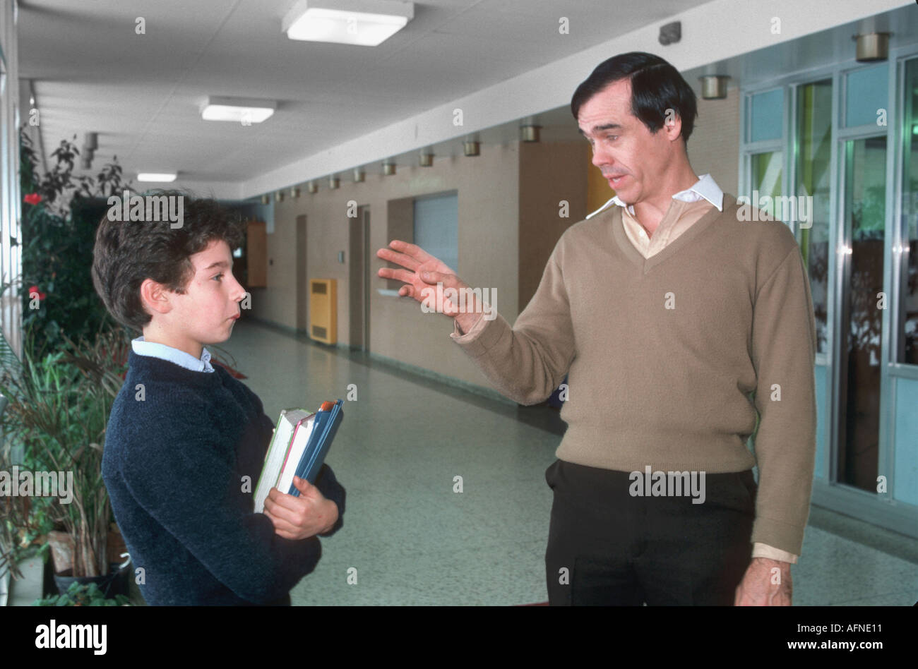 Teacher scolds student in the hall between classes Stock Photo