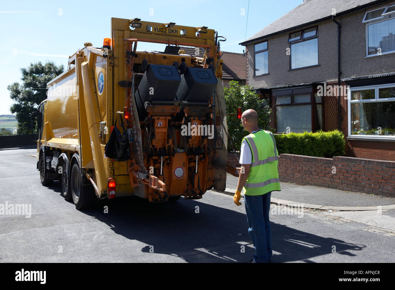 WHEELIE BINS LOADING RUBBISH ONTO YELLOW REFUSE TRUCK Stock Photo Alamy