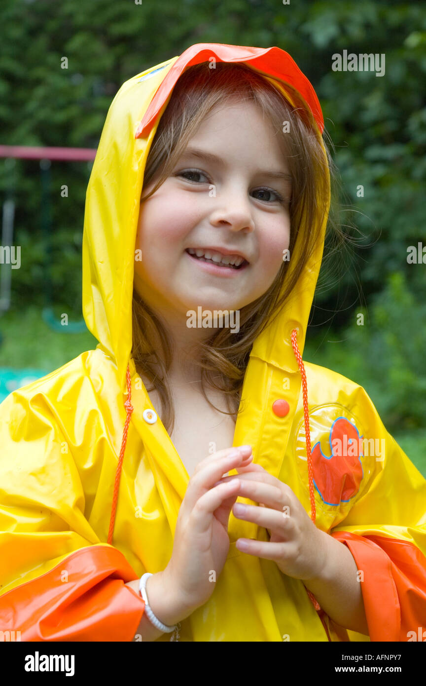 Young girl playing out in the rain in her yellow rain coat Stock Photo