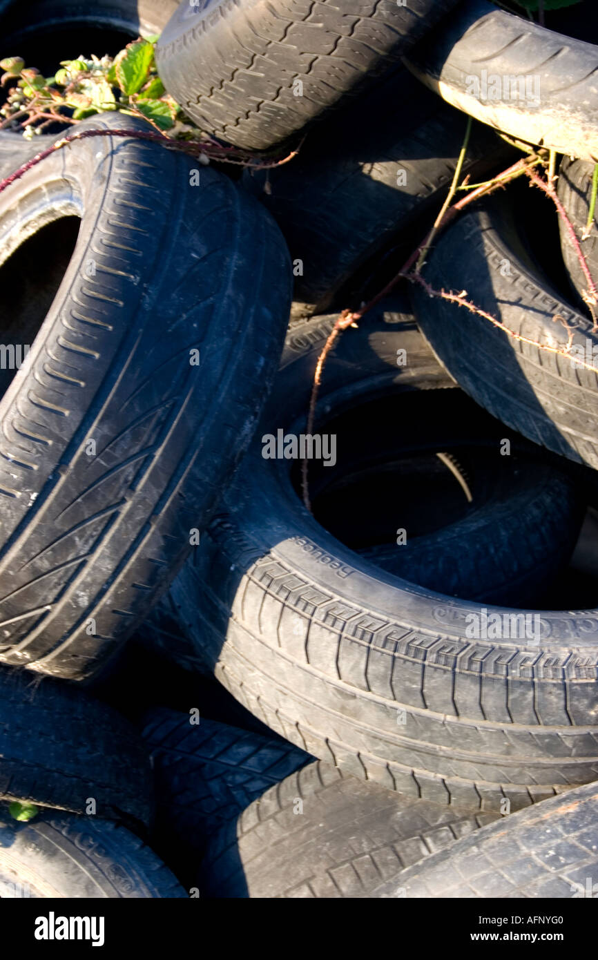 Worn rubber car automobile tires, tyres in a pile Used to hold down plastic sheeting over silage Stock Photo