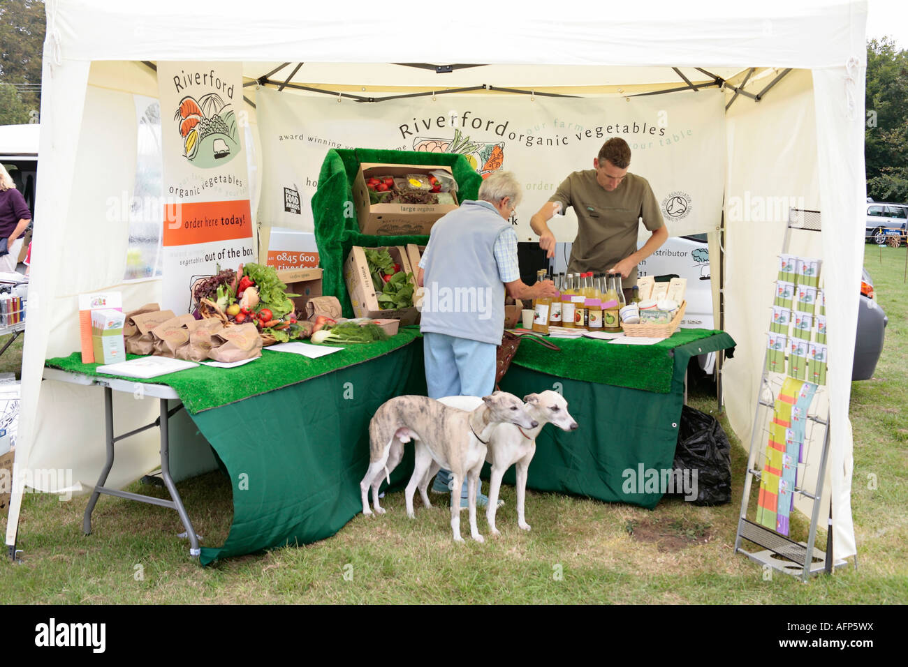 Lady buying produce from organic stall at local village fair in West Sussex, England, UK Stock Photo