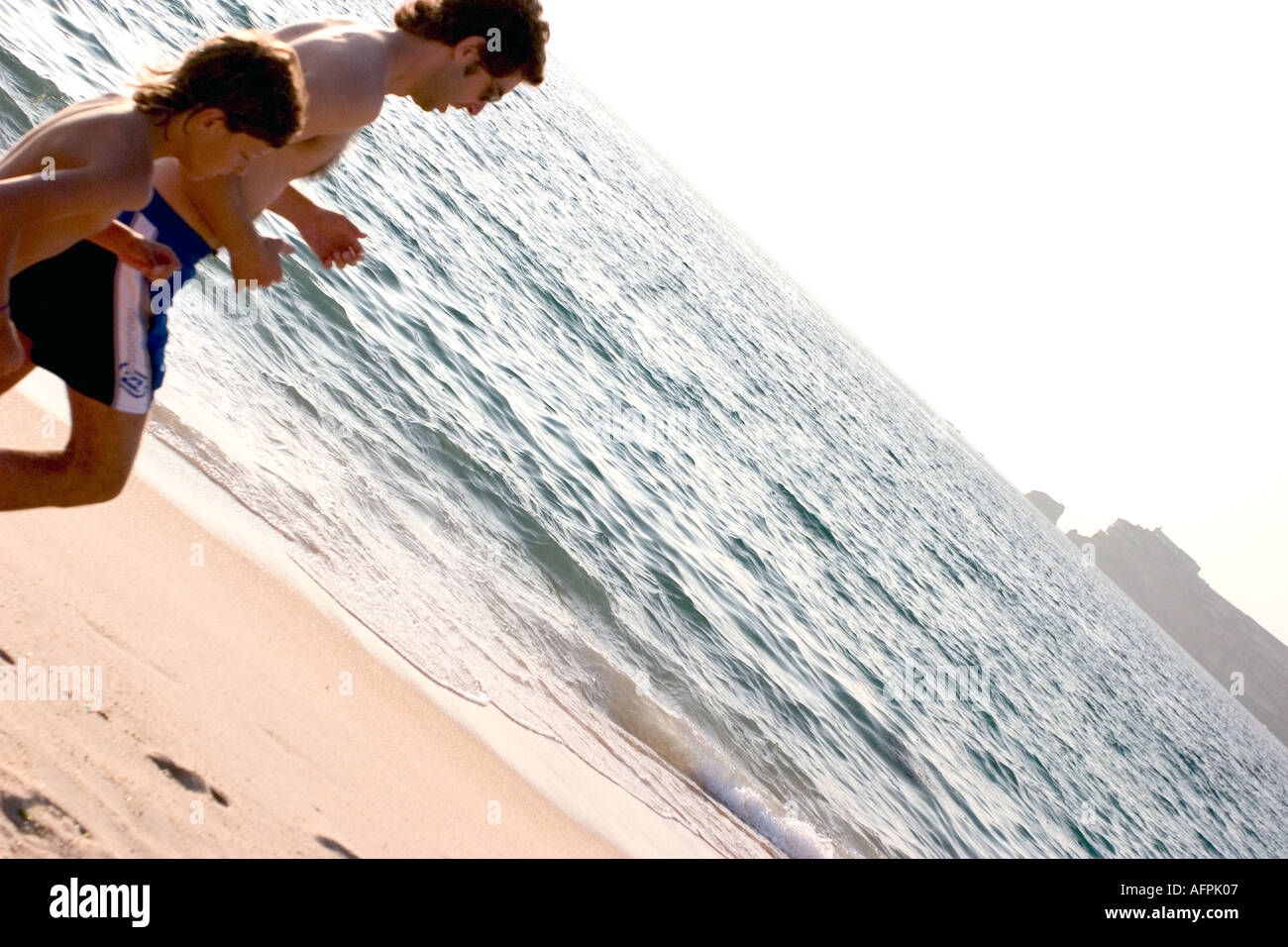 man jogging in nazare beach portugal during sunset time end of day Stock Photo