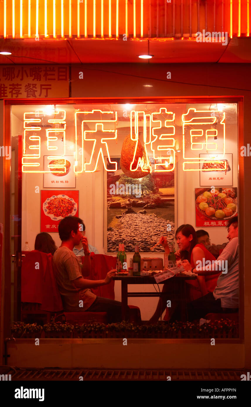 View through restaurant window of people eating, Dongzhimen Nei Dajie. Beijing, China Stock Photo