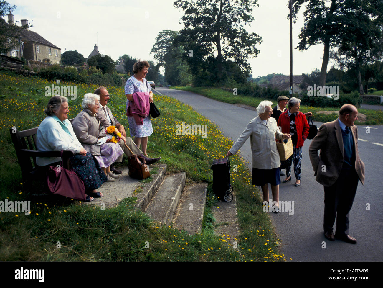 Village people wait at for a rural bus to arrive. Eastleach Turville Gloucestershire England. 1990s 1993 HOMER SYKES Stock Photo
