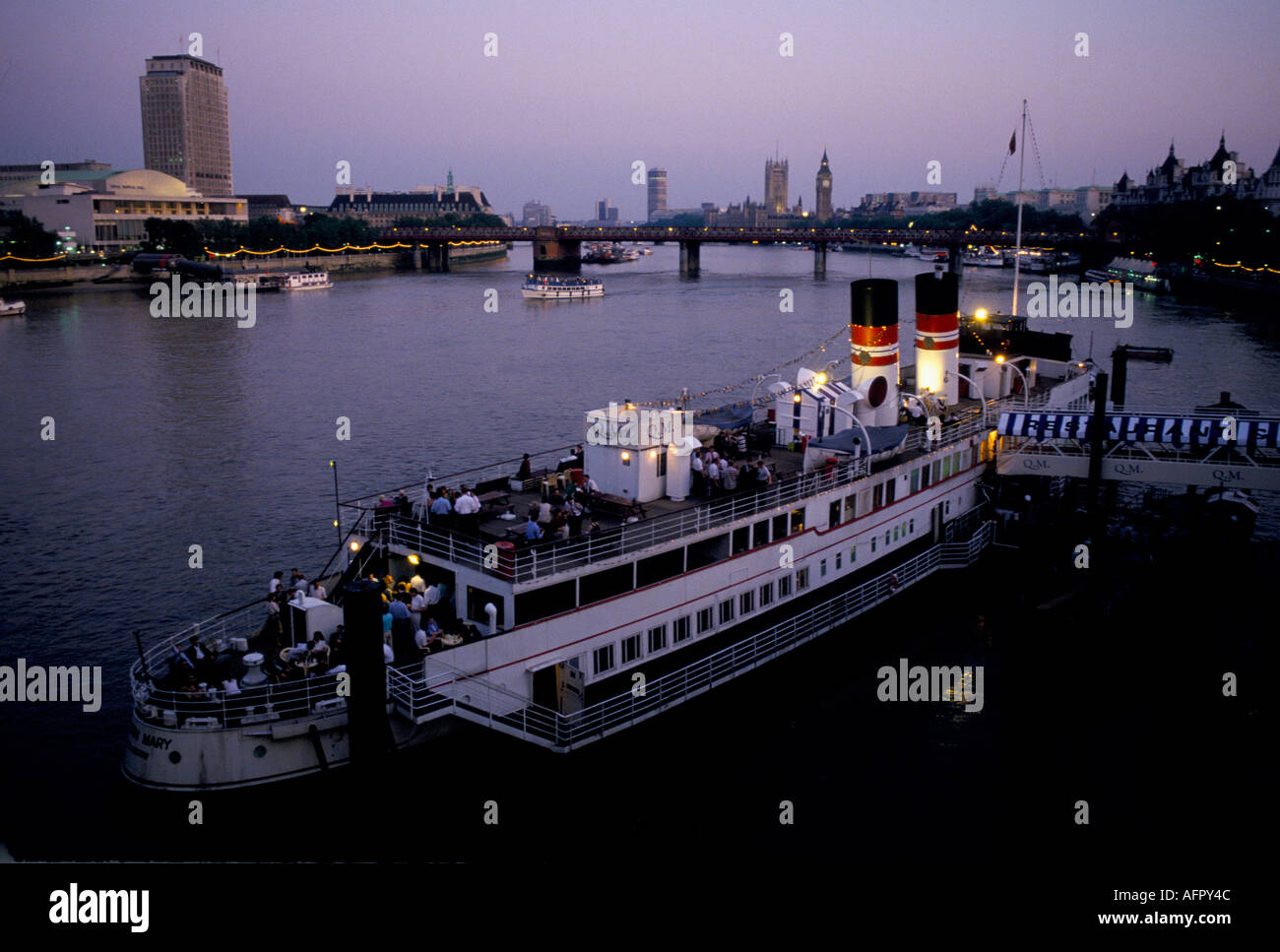 River Thames river boat restaurant in central London. England 1990s. UK. View across the Thames to the South Bank Centre. Big Ben Houses of Parliament. Stock Photo