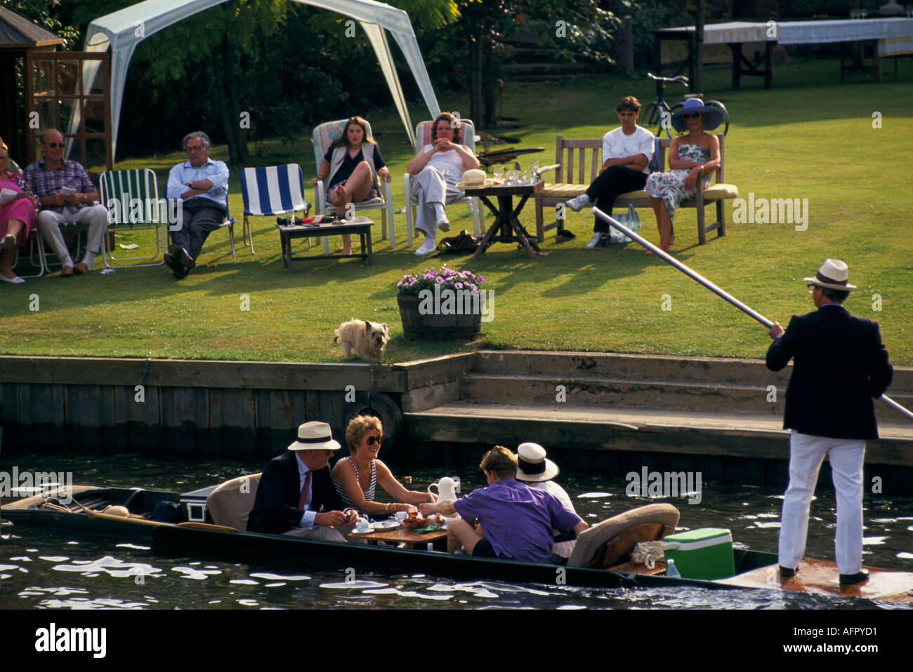 Wealthy lifestyle, family with garden backing onto the river Thames, watching the racing. People having tea in punt. Henley on Thames  UK 2000s 20006 Stock Photo