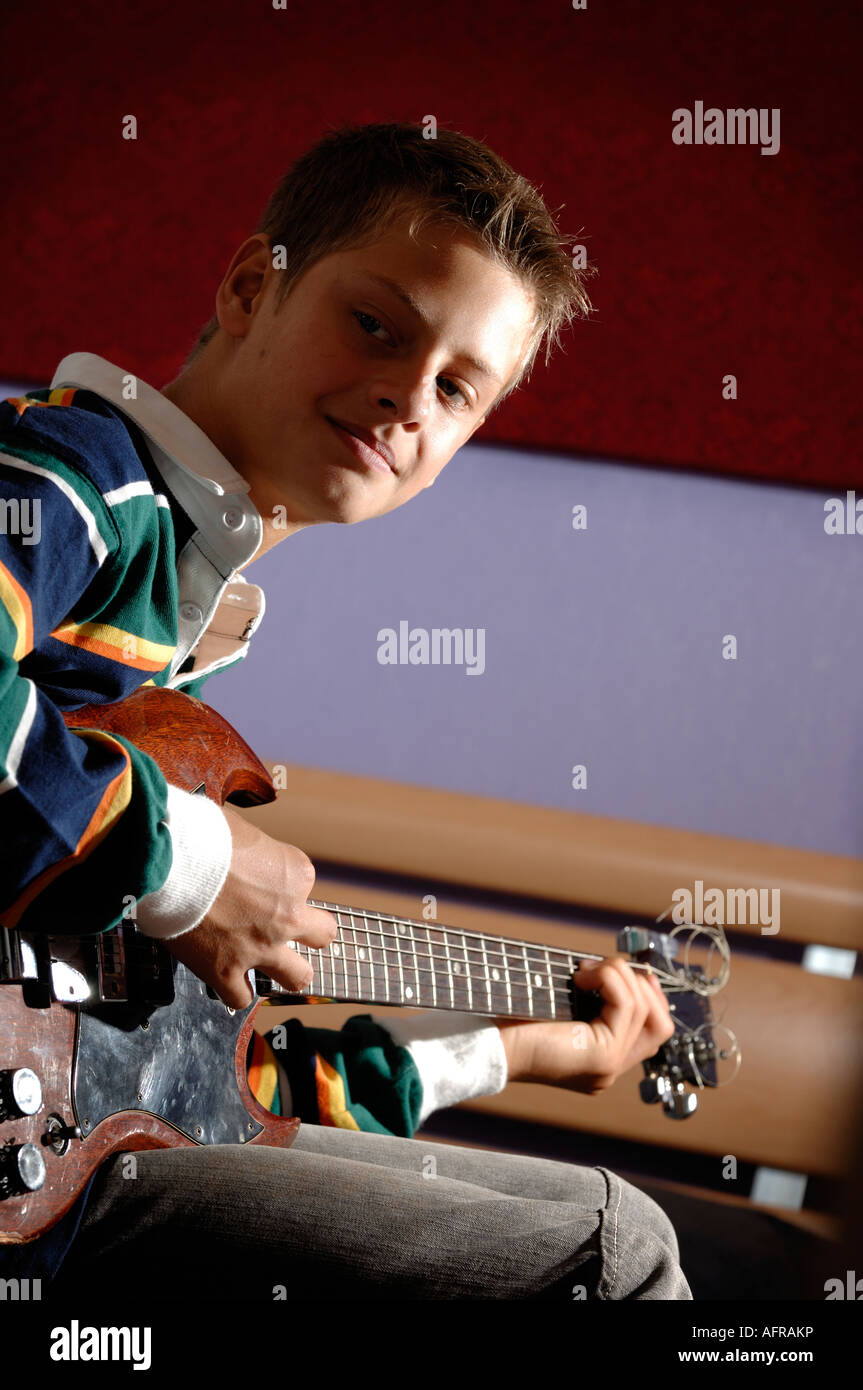 Boy in bedroom playing a guitar Stock Photo
