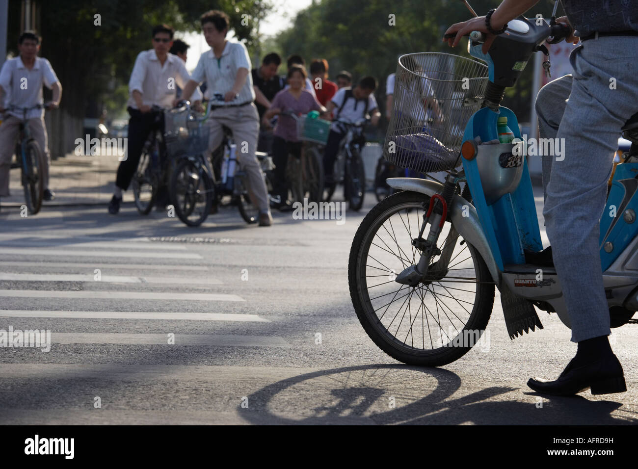Motorcyclist and cyclists waiting at crossing, Beijing, China. Stock Photo