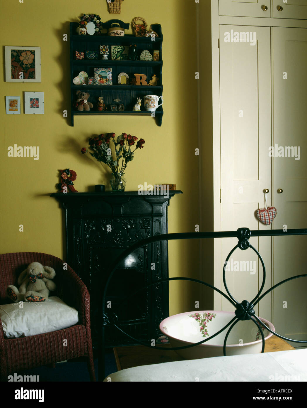 Miniature Shelves Above Small Black Cast Iron Fireplace In Yellow