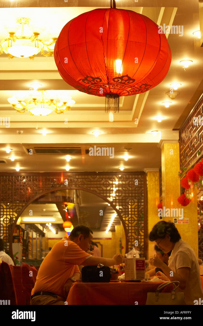 View through restaurant window of couple eating, Dongzhimen Nei Dajie, Beijing, China. Stock Photo