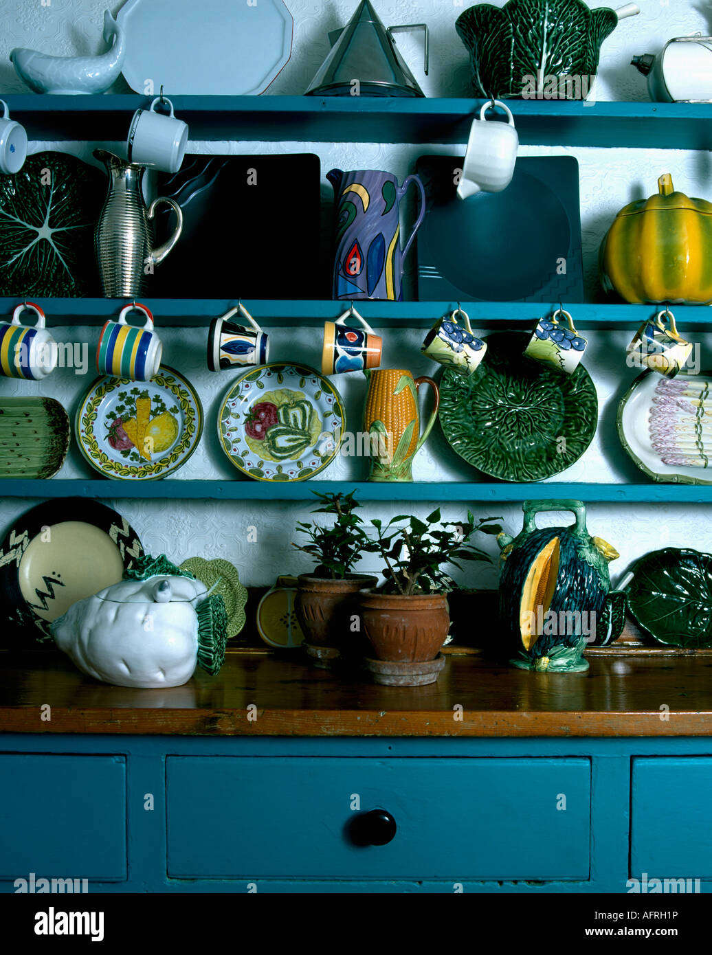 Pottery Cups And Plates On Blue Shelves Above Dresser With Wooden