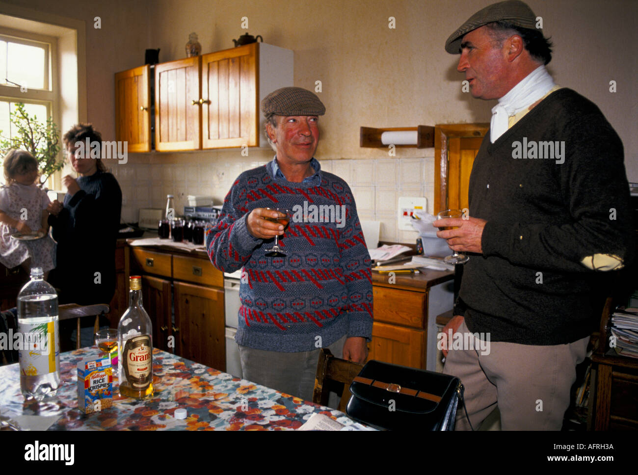 Ian Farquhar (R) local farmer and hunt members with stirrup cup farm kitchen end of day Duke of Beaufort Hunt Gloucestershire 1990s UK HOMER SYKES Stock Photo