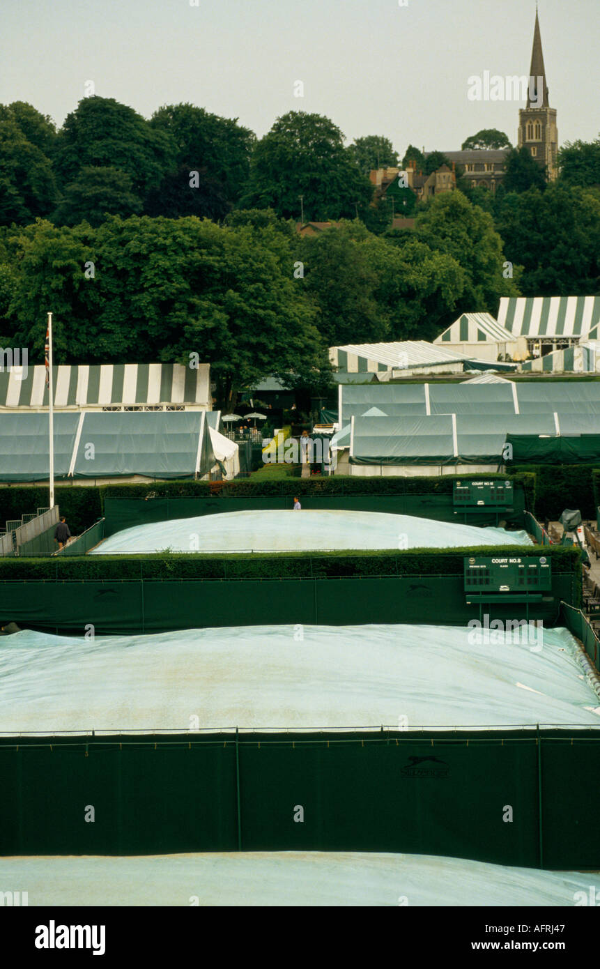 Wimbledon tennis 1980s, weather covers on the courts after the end of  play.  Wimbledon tennis championships.1985 St Marys Church spire HOMER SYKES Stock Photo
