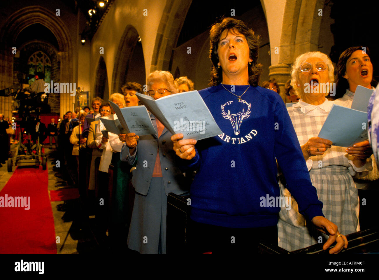 Singing in church of Saint St Nectan at Stoke, Hartland, Devon. Filming, BBC One outside broadcast 'Songs of Praise' UK. HOMER SYKES Stock Photo