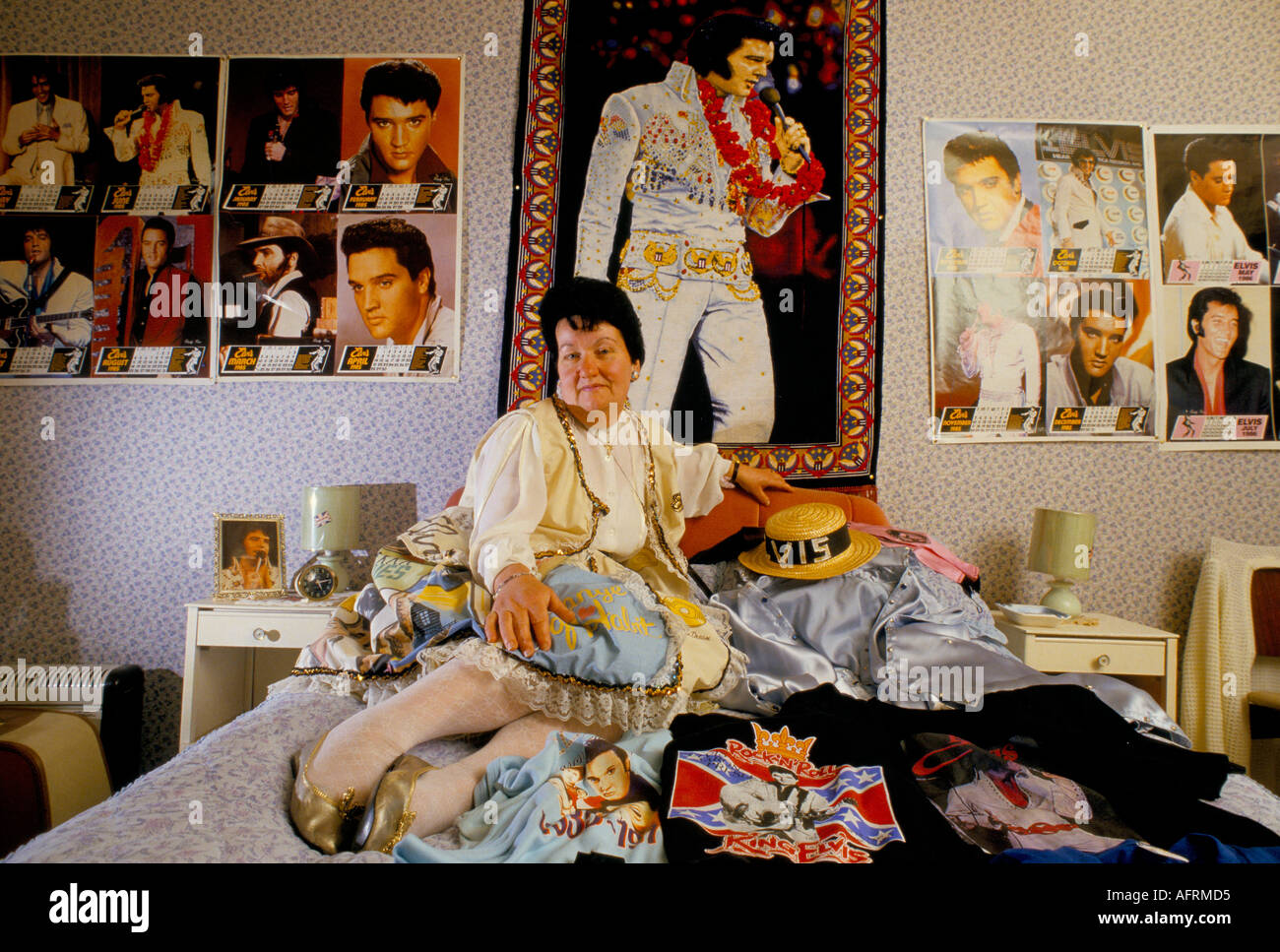 Elvis Presley fan with memorabilia and wearing an Elvis patterned dress and earrings. This is her tribute bedroom. 1990s 90s HOMER SYKES Stock Photo