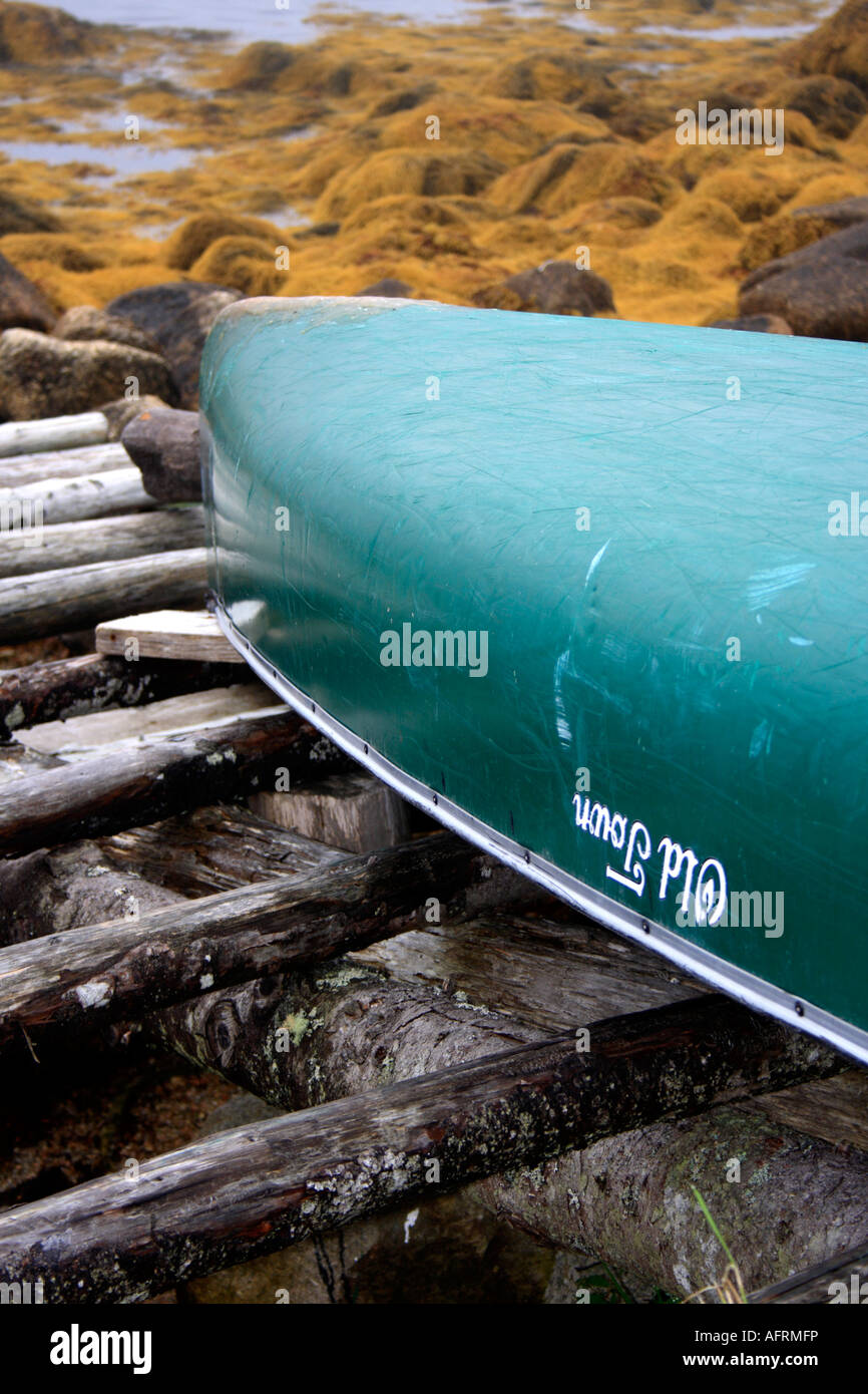 Old Town Canoe lying upside down on oceanside boat ramp, Nova Scotia