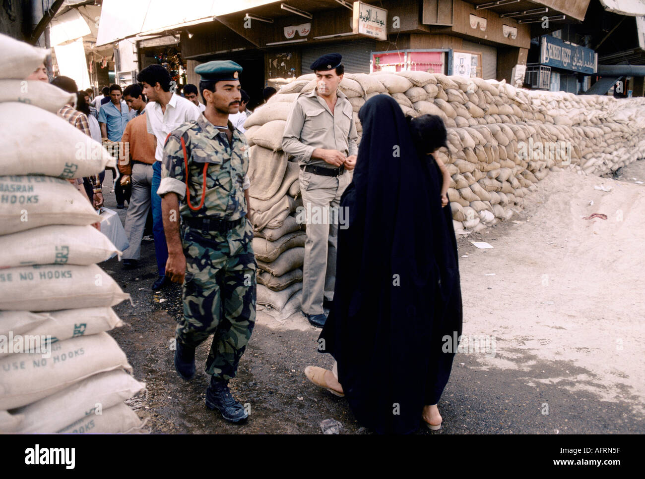 Basra Iraqi sandbags sandbag wall in the street, soldiers  and people daily life. 1984.1980s HOMER SYKES Stock Photo