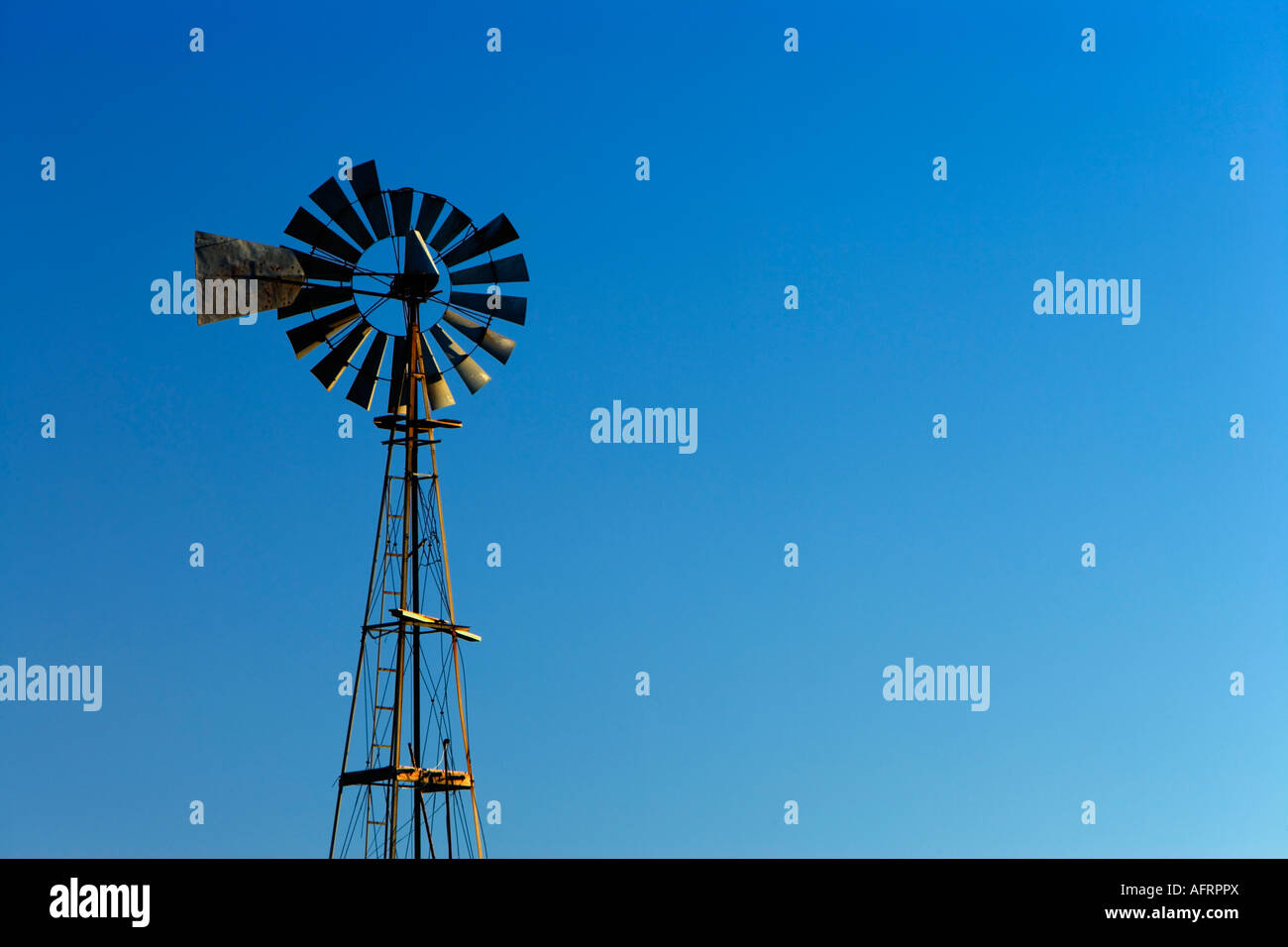 Agricultural windmill against a blue sky. Stock Photo