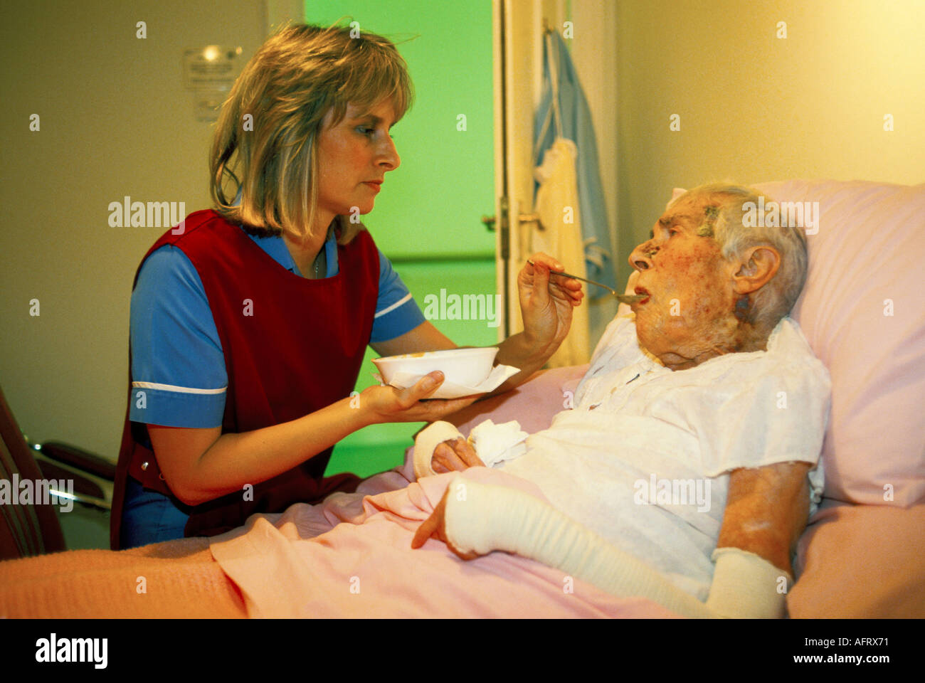Nurse in care home feeding an elderly woman resident Nursing an old are