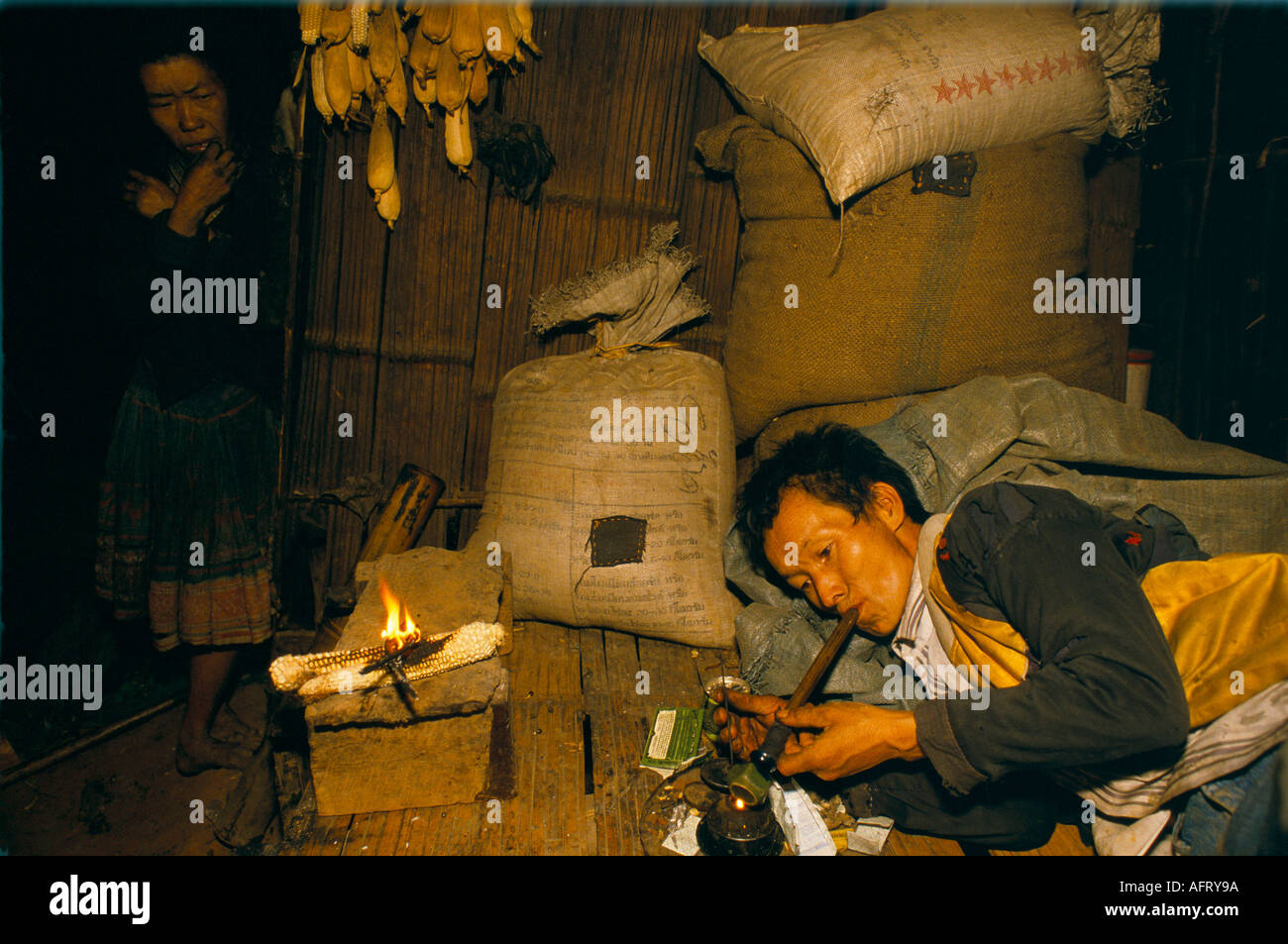 Drug addict Thailand Opium addiction Hmong tribesman man in  Opium Den smoking an opium pipe. Village in Golden Triangle 1990S HOMER SYKES Stock Photo