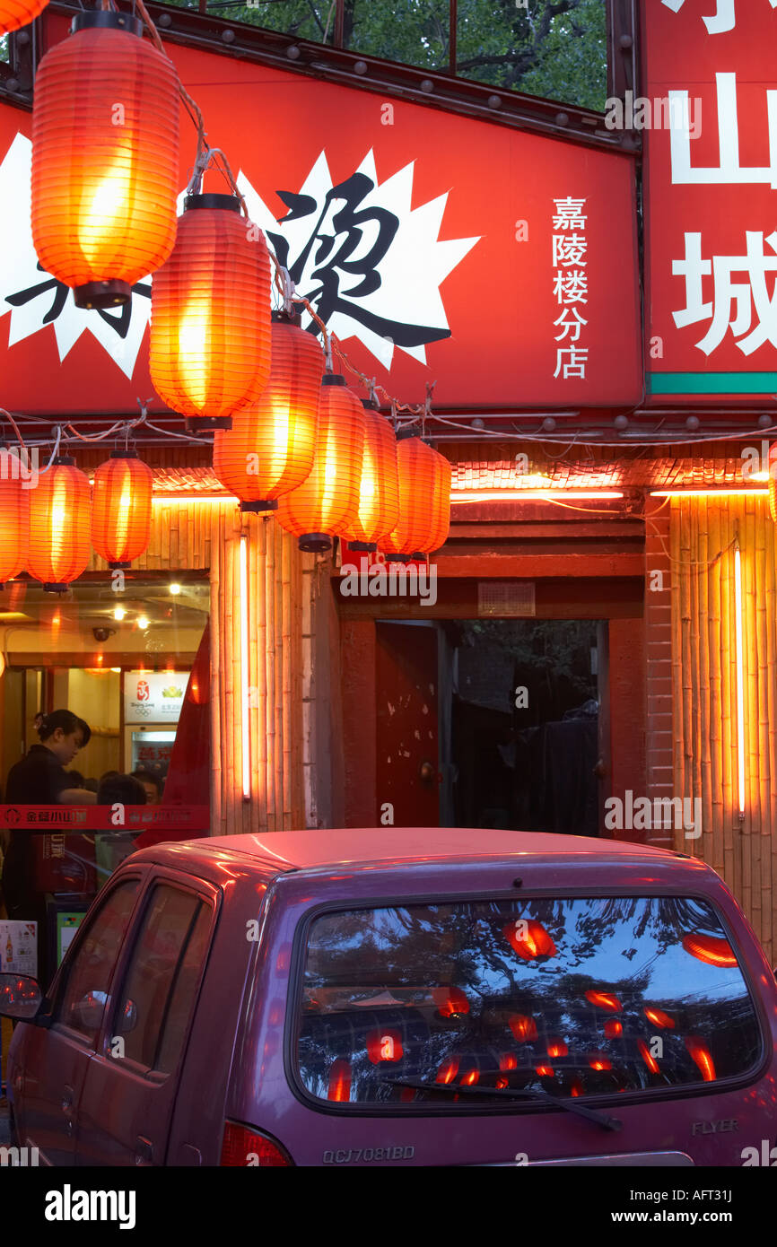 Red lanterns and car parked directly in font of restaurant, Dongzhimen Nei Dajie, Beijing, China. Stock Photo