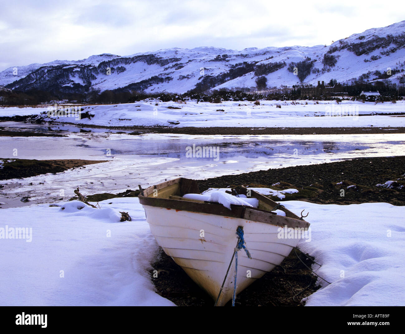 GLENELG SCOTTISH HIGHLANDS UK February Looking out over Glenmore River with a moored boat in the foreground in snow Stock Photo
