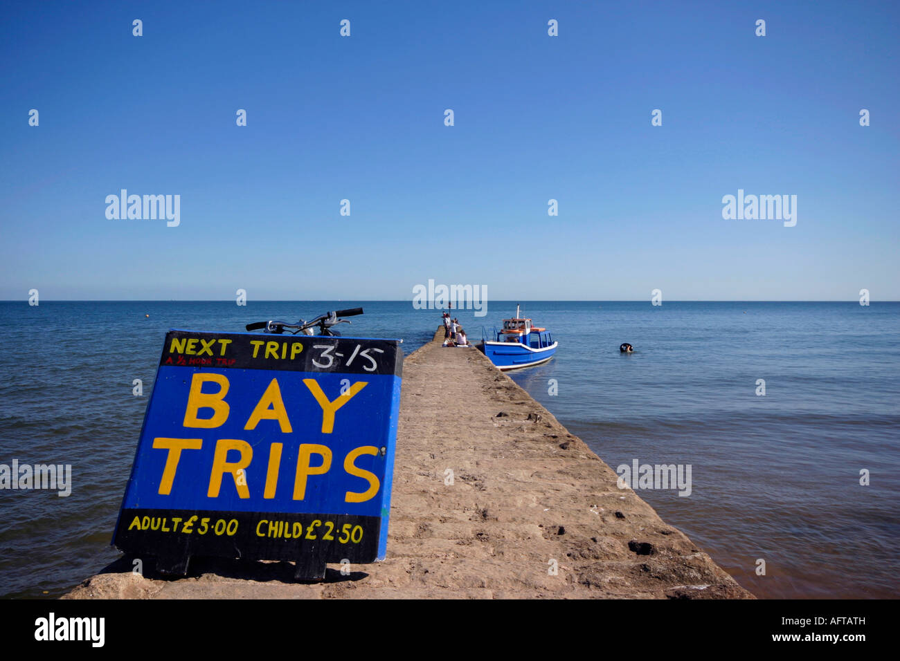 The pier at Dawlish in Devon UK with a sign for a boat offering trips