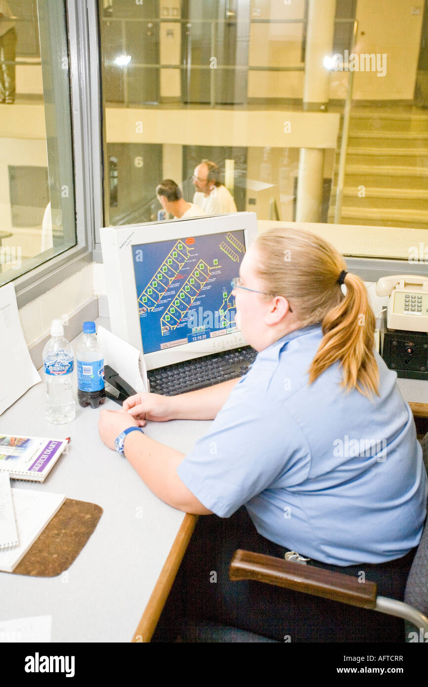 Female correctional officer monitoring cctv monitors. Diagnostics and