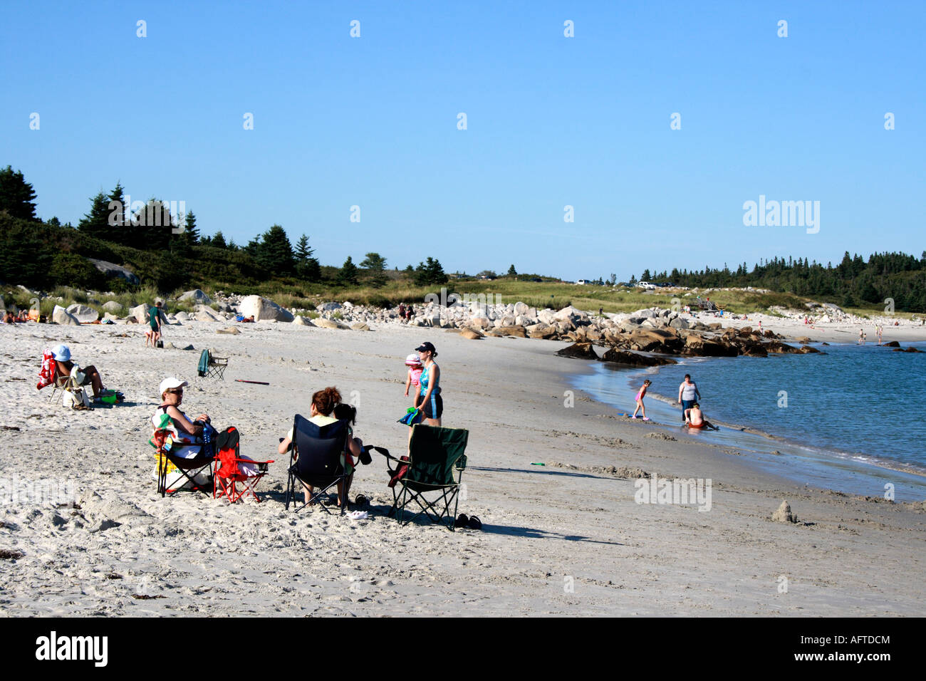 sunbathers on the sandy shore of Crystal Crescent Beach, Halifax, Nova Scotia, Canada. Photo by