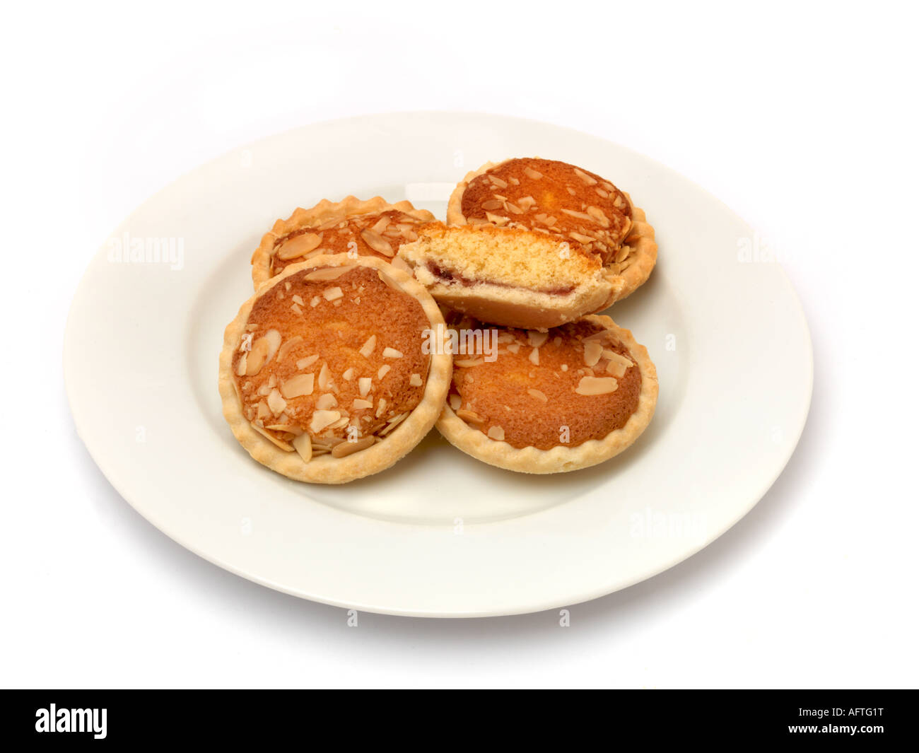 A Plate Of Bakewell Tarts one Cut in Halk to Show Filling Stock Photo