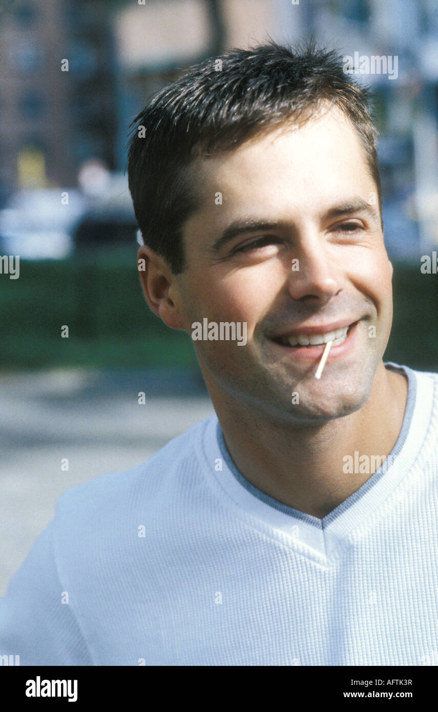 Young man with toothpick in mouth close up Stock Photo Alamy