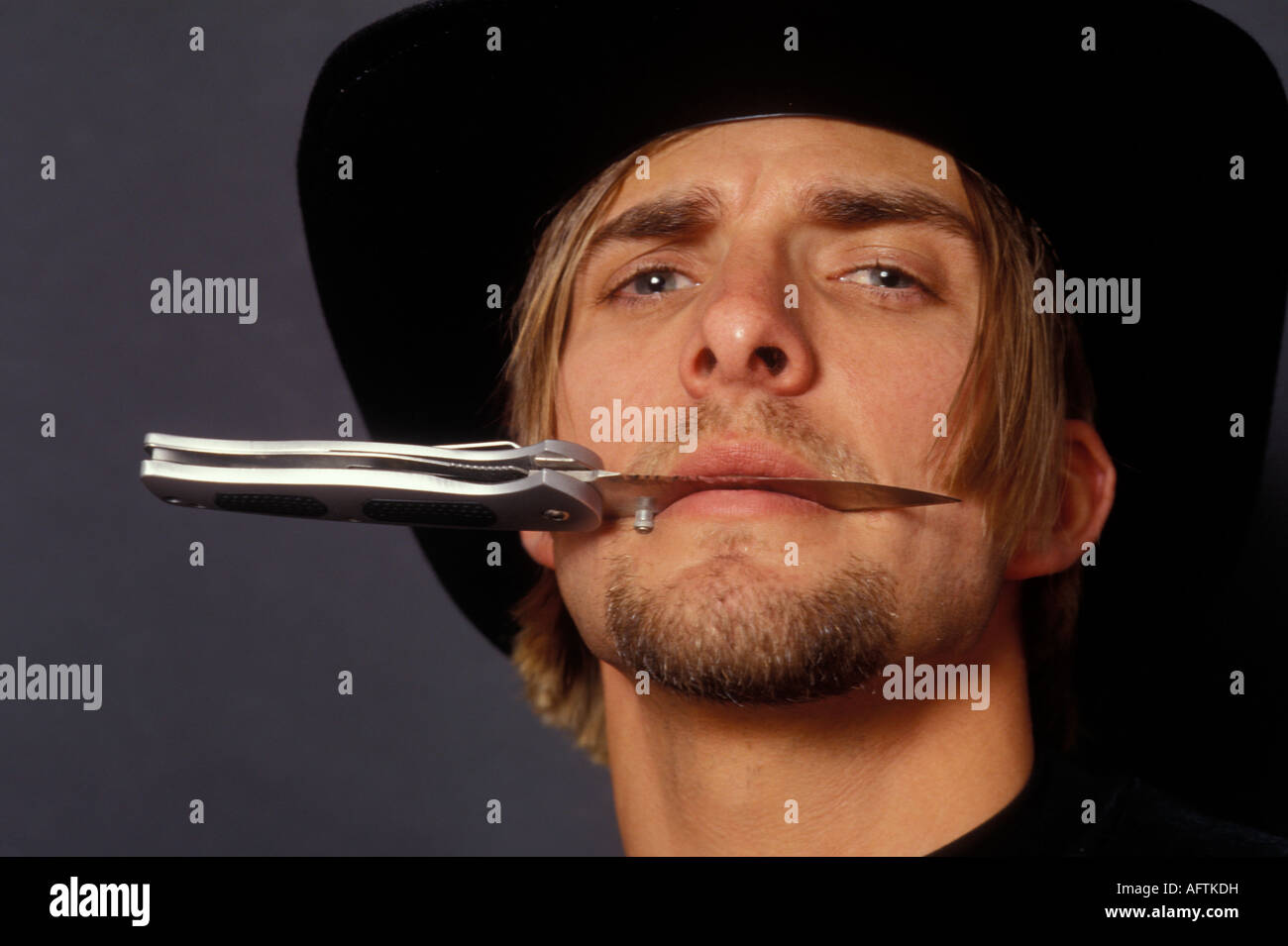 Man holding knife in mouth, portrait Stock Photo Alamy