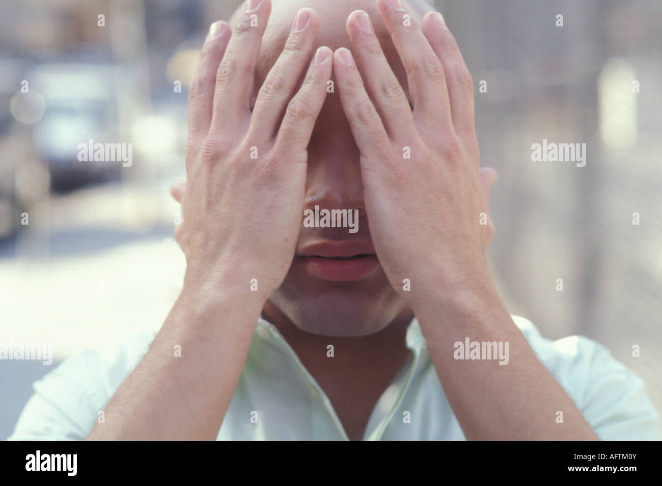 Young man covering face with hands Stock Photo - Alamy