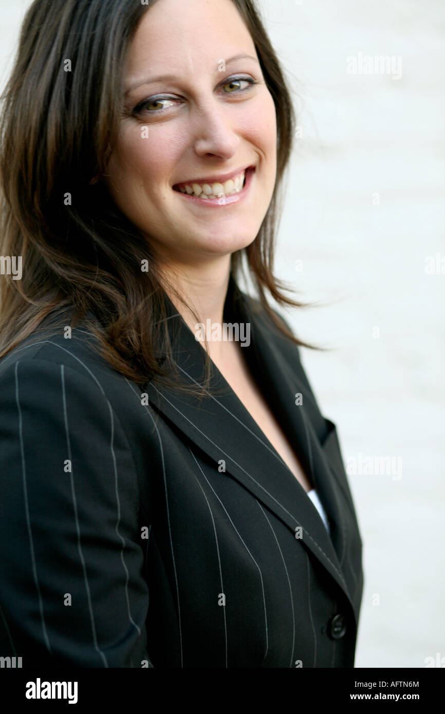Young woman standing in front of wall, portrait Stock Photo - Alamy