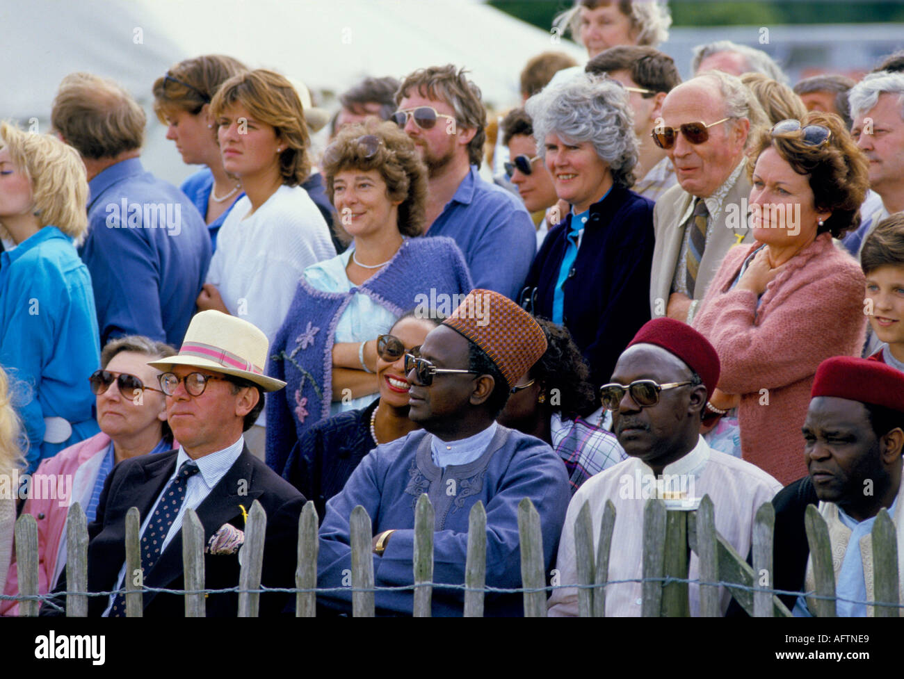 Multicultural group people watching polo game being played Cowdray Park Sussex Uk 1980s HOMER SYKES Stock Photo