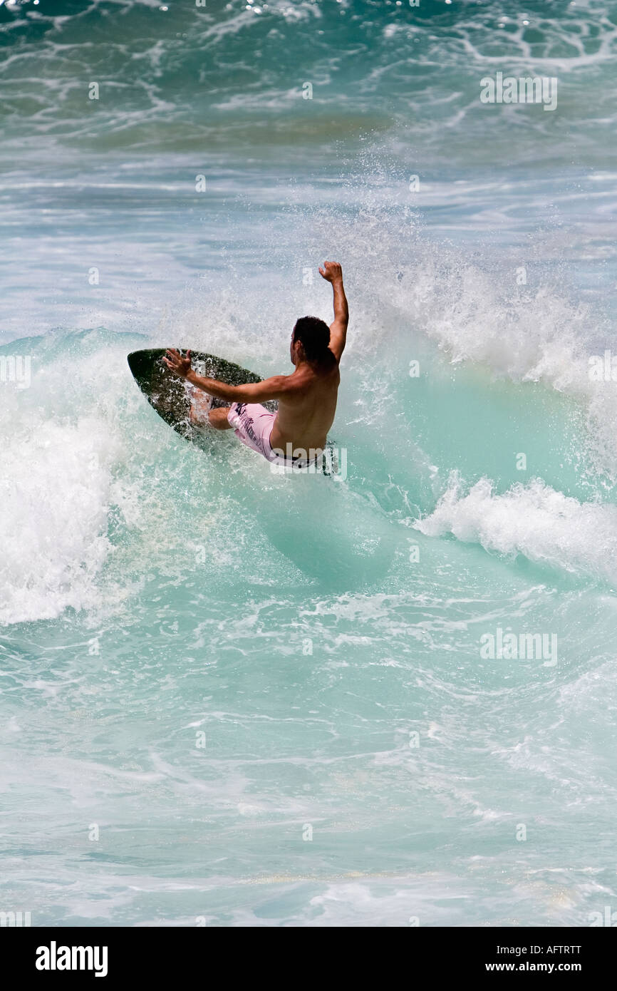 Surfer surfing on breaking wave using a skimboard Stock Photo Alamy