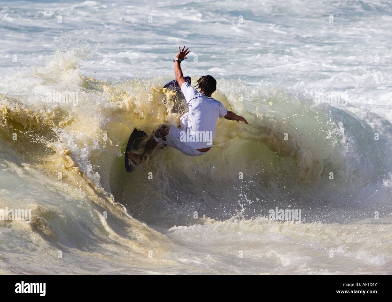 Surfer surfing on breaking wave using a skimboard Stock Photo Alamy
