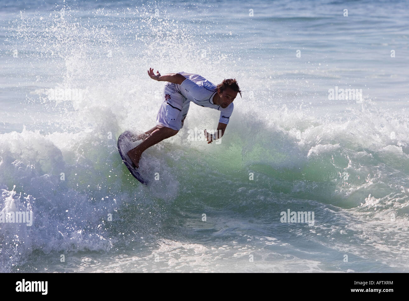 Surfer surfing on breaking wave using a skimboard Stock Photo Alamy